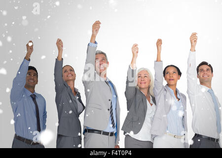 Zusammengesetztes Bild des Lächelns Geschäftsleute Hände erhebend Stockfoto