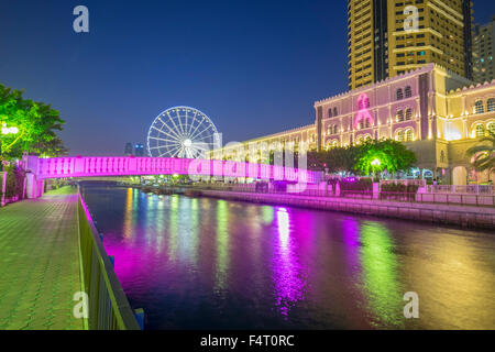 Abends Blick auf Eye of the Emirate Riesenrad und Al Qasba Vergnügungsviertel in Sharjah, Vereinigte Arabische Emirate Stockfoto