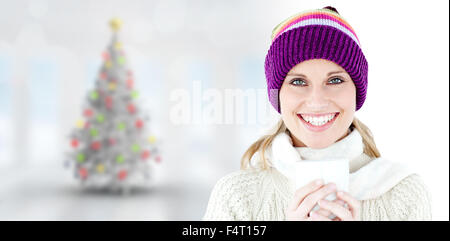 Zusammengesetztes Bild leuchtende Frau trägt einen weißen Pullover und einem bunten Hut gegen weiße staatlich Stockfoto