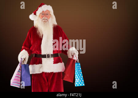 Zusammengesetztes Bild von Santa trägt einige Weihnachts-Taschen Stockfoto