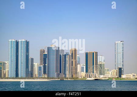 Tagsüber Skyline-Blick auf Strand und moderne Apartment-Hochhäuser entlang der Corniche in Sharjah, Vereinigte Arabische Emirate Stockfoto