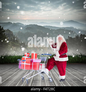 Zusammengesetztes Bild von Santa, die Geschenke aus dem Warenkorb zu liefern Stockfoto