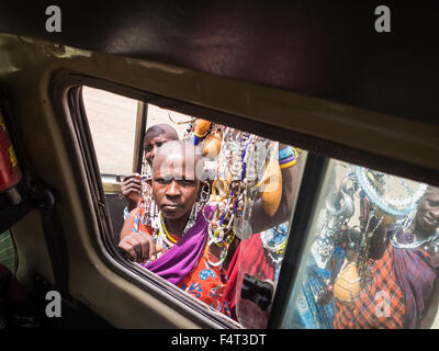 Massai-Frauen bieten Souvenirs an Touristen durch ein Autofenster in Arusha Region, Tansania, Afrika. Stockfoto