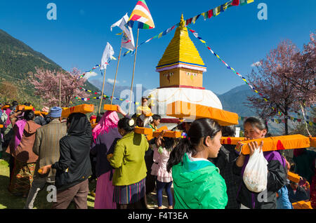 Menschen, die tibetische Gebetbücher, eingehüllt in gelb Material auf ihren Köpfen Lhapab Tuchen Festival Stockfoto