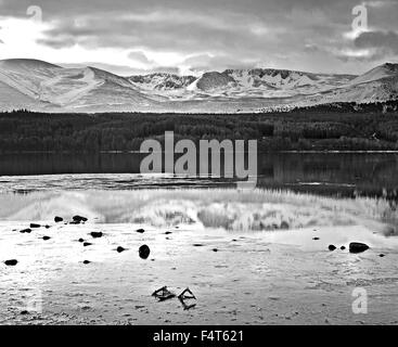 Schwarzweißansicht des Cairngorm Plateaus gesehen über teilweise gefroren Loch Morlich, winter, Cairngorms, schottischen Highlands, UK Stockfoto