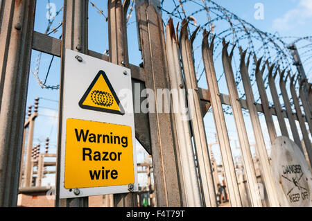 Warnschild an einem Zaun zu einem Strom Umspannwerk Warnung der Existenz von Stacheldraht. Stockfoto