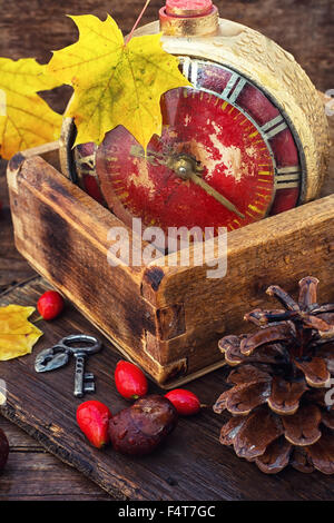 alte Uhr auf gefallenen Ahornblatt im Herbst Stil fest Stockfoto