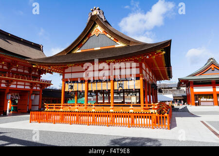 Japan, Koyto, Fushimi. Berühmte Inari Schrein. Zinnoberrot verzierten Shinto Bühne Gebäude in der Mitte des leeren Innenhof. Strahlender Sonnenschein. Blue Sky. Stockfoto