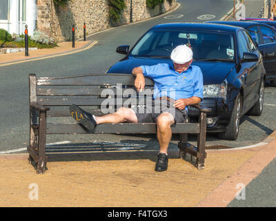 OAP schlafen auf Bank Stockfoto