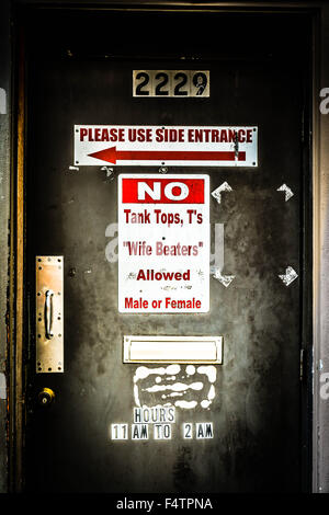 Dress-Code geschrieben am funky Beat-up Tür des Dive bar "erlaubt keine Tank-Tops, T-Shirts oder Frau Schläger, männlich oder weiblich" Stockfoto