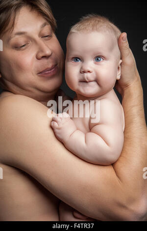 Porträt von glücklichen Menschen halten niedlichen Baby junge und blickte ihn. Stockfoto