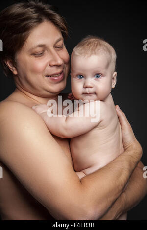 Porträt von glücklichen Menschen halten niedlichen Baby junge und blickte ihn. Stockfoto