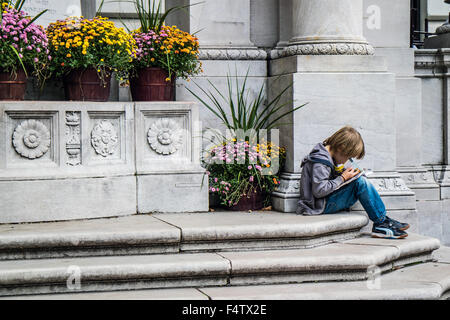 NEW YORK, USA, 9. Oktober 2015: Ein nicht identifizierter junge Lesen eines Buches im Bryant Park in Manhattan, New York City. Stockfoto
