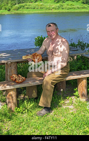 Handgefertigte Holz Vase und Löffel geschnitzt. Porträt des Holzschnitzers an der Fluss-Küste. Stockfoto