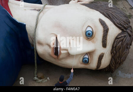 Pudagla, Deutschland. 14. Oktober 2015. Ein Arbeiter reinigt den Kopf der Figur "Gulliver" mit einem Schlauch in der "Gullivers Welt" Erlebnispark auf der Insel Usedom in Pudagla, Deutschland, 14. Oktober 2015. Die Figur muss gereinigt werden, um wetterbedingten Schäden im Winter zu vermeiden. Die Skulptur 'Gulliver in Liliput' ist 36 Meter lang und 17 Meter breit, so dass es eines der größten seiner Art in Europa. Foto: STEFAN SAUER/Dpa/Alamy Live News Stockfoto