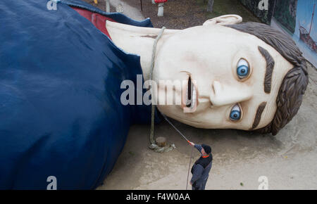 Pudagla, Deutschland. 14. Oktober 2015. Ein Arbeiter reinigt den Kopf der Figur "Gulliver" mit einem Schlauch in der "Gullivers Welt" Erlebnispark auf der Insel Usedom in Pudagla, Deutschland, 14. Oktober 2015. Die Figur muss gereinigt werden, um wetterbedingten Schäden im Winter zu vermeiden. Die Skulptur 'Gulliver in Liliput' ist 36 Meter lang und 17 Meter breit, so dass es eines der größten seiner Art in Europa. Foto: STEFAN SAUER/Dpa/Alamy Live News Stockfoto