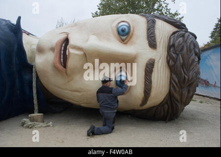 Pudagla, Deutschland. 14. Oktober 2015. Ein Arbeiter reinigt den Kopf der Figur "Gulliver" mit einem Pinsel in der "Gullivers Welt" Erlebnispark auf der Insel Usedom in Pudagla, Deutschland, 14. Oktober 2015. Die Figur muss gereinigt werden, um wetterbedingten Schäden im Winter zu vermeiden. Die Skulptur 'Gulliver in Liliput' ist 36 Meter lang und 17 Meter breit, so dass es eines der größten seiner Art in Europa. Foto: STEFAN SAUER/Dpa/Alamy Live News Stockfoto