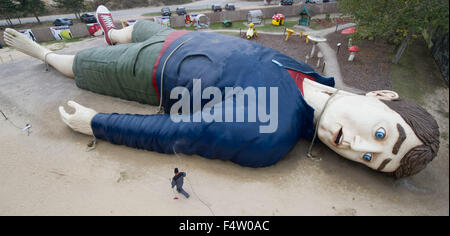 Pudagla, Deutschland. 14. Oktober 2015. Ein Arbeiter reinigt die Hand der Figur "Gulliver" mit einem Schlauch in der "Gullivers Welt" Erlebnispark auf der Insel Usedom in Pudagla, Deutschland, 14. Oktober 2015. Die Figur muss gereinigt werden, um wetterbedingten Schäden im Winter zu vermeiden. Die Skulptur 'Gulliver in Liliput' ist 36 Meter lang und 17 Meter breit, so dass es eines der größten seiner Art in Europa. Foto: STEFAN SAUER/Dpa/Alamy Live News Stockfoto