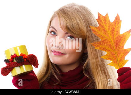 Glückliche Frau tragen Wolle Schal und Handschuhe, halten dekoriert gelbe Tasse heißen Tee und rote gelbe herbstlichen Blatt, Stockfoto