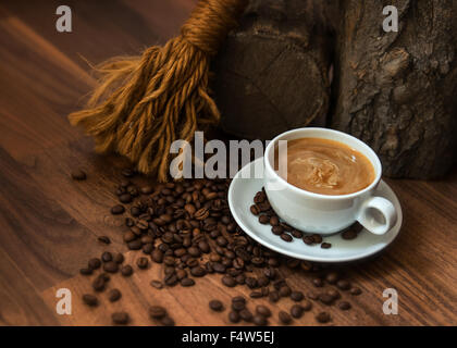 Tasse Kaffee mit Bohnen in erdigen Einstellung Stockfoto