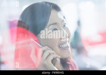 Schließen Sie sich lächelnd Geschäftsfrau, reden über Handy Stockfoto