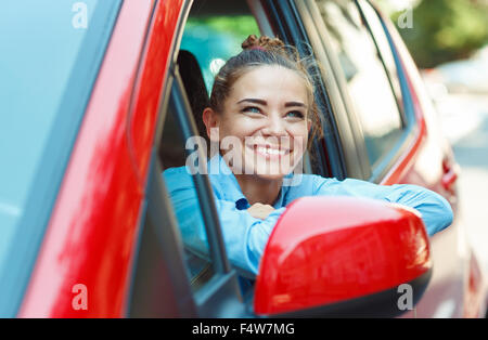 Junge lächelnde Frau, die ihr Auto zu fahren Stockfoto