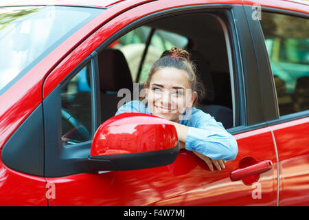 Junge lächelnde Frau, die ihr Auto zu fahren Stockfoto