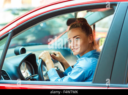 Junge lächelnde Frau, die ihr Auto zu fahren Stockfoto