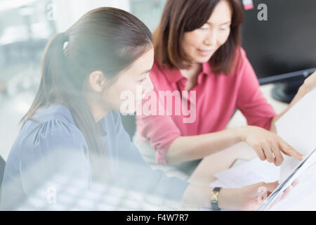 Geschäftsfrauen diskutieren Papierkram im Büro Stockfoto