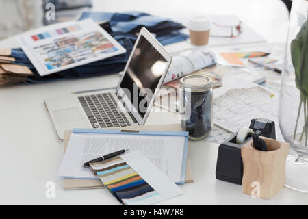 Laptop, Farbfelder, Proofs und Papierkram am Schreibtisch in Mode Schreibtisch Büro Stockfoto