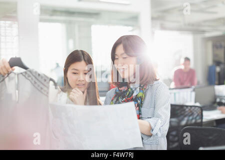 Mode-Designer mit Kleidung und Schnittmuster im Büro Stockfoto