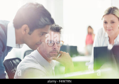 Geschäftsleute, die am Computer in sonnigen Büro Stockfoto