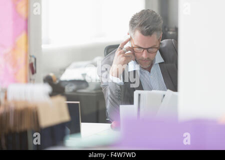 Konzentrierte sich Geschäftsmann Überprüfung Papierkram am Schreibtisch im Büro Stockfoto
