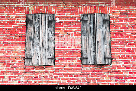 Fenster mit Holzrahmen auf roten Backsteinmauer. Stockfoto