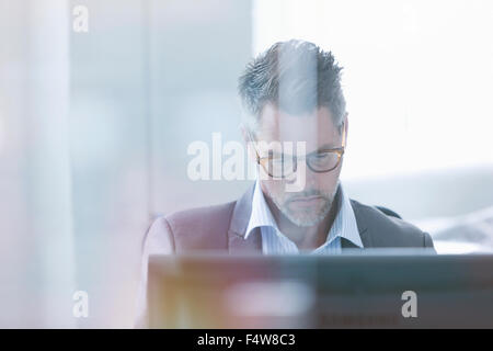 Fokussierte Geschäftsmann mit Computer im Büro Stockfoto