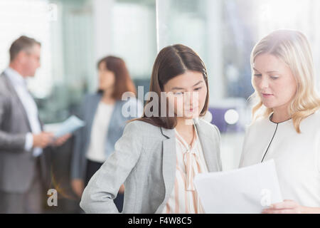 Geschäftsfrauen diskutieren Papierkram im Büro Stockfoto