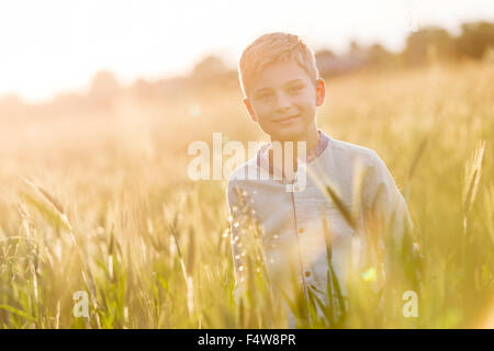 Porträt lächelnde junge im sonnigen ländlichen Weizenfeld Stockfoto