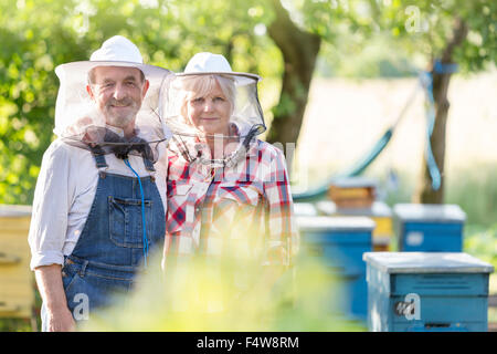 Porträt zuversichtlich Imker in schützende Hüte in der Nähe von Bienenstöcken Stockfoto