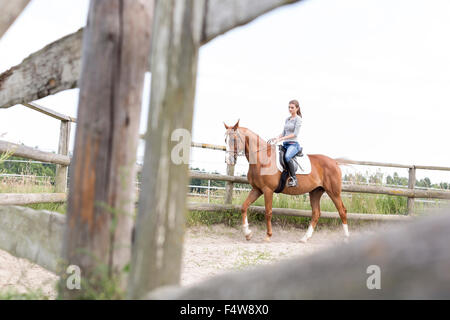 Frau Reiten in ländlichen eingezäunten Weide Stockfoto