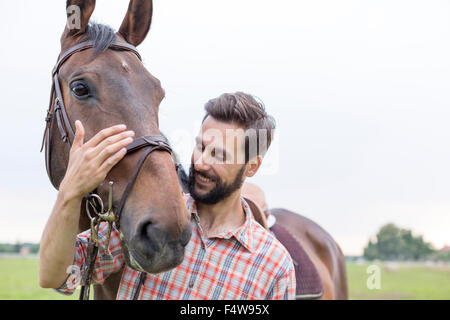 Lächelnd Mann umarmt Pferd Stockfoto
