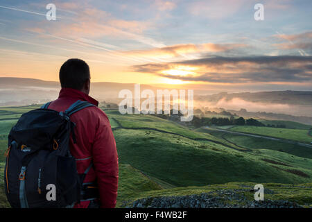 Wanderer genießen die Aussicht über ein Misty Teesdale bei Sonnenaufgang aus Kirkcarrion, Lunedale, Teesdale County Durham UK Stockfoto