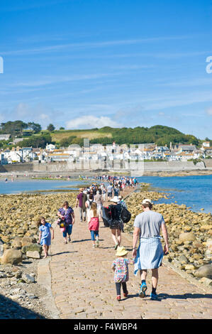 Ein Blick auf die Menschen zu Fuß zum und vom St. Michaels Mount entlang der Damm mit der Stadt von Marazion im Hintergrund. Stockfoto