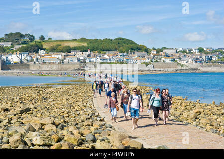 Ein Blick auf die Menschen zu Fuß zum und vom St. Michaels Mount entlang der Damm mit der Stadt von Marazion im Hintergrund. Stockfoto