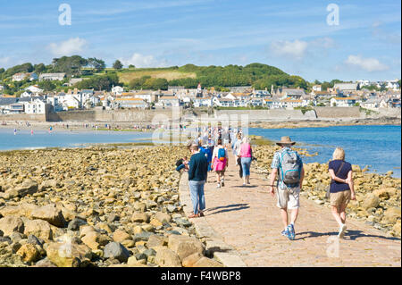 Ein Blick auf die Menschen zu Fuß zum und vom St. Michaels Mount entlang der Damm mit der Stadt von Marazion im Hintergrund. Stockfoto