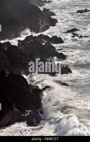 Energische Wellen schlagen auf Felsen in St. Annes Head in Pembrokeshire, Wales. Stockfoto