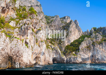 Kleinen touristischen Motorboot betritt die Grotte in Küstenfelsen der Insel Capri, Italien Stockfoto