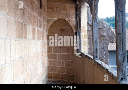 Schmale Passage Kopfsteinpflaster mit Bögen außerhalb der Kirche St. Nikolaus in Orio. Baskisches Land. Stockfoto