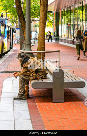 Obdachlosen Mann sitzt auf einer Sitzbank in der Innenstadt von Portland Oregon Stockfoto