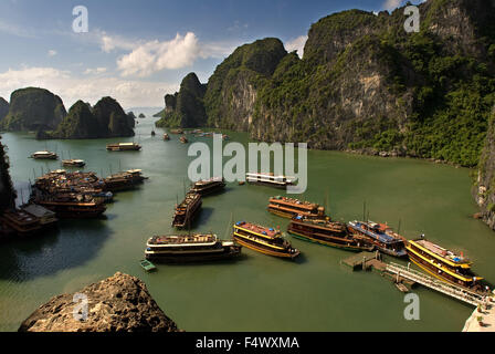 Schiffe in die Halong-Bucht in der Nähe von Hang Sung Sot Grotte. Ein Bergsteiger verweist auf Kalksteinfelsen in der Halong Bucht, Vietnam. Dschunken in Halong Bay in Vietnam gesehen vom Eingang zum Hang Sung Sot Grotte. Halong Bay hat Tausende von kletterbaren Kalkstein-Formationen durch. Stockfoto