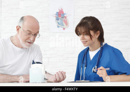 Arzt messen Blutdruck senior männlichen Patienten Stockfoto
